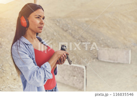 Woman releasing stress, Instructor helping woman with gun 116835546