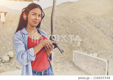 Woman releasing stress, Instructor helping woman with gun 116835548