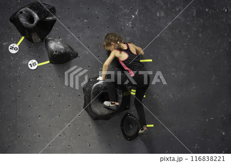 Little girl trained climbs artificial wall at 116838221