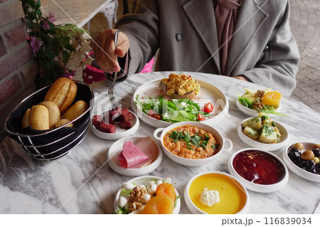 woman is enjoying turkish breakfast at cafe  116839034