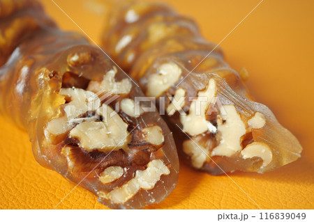 Closeup of a sweet treat made with walnuts and grape molasses, on an orange background 116839049