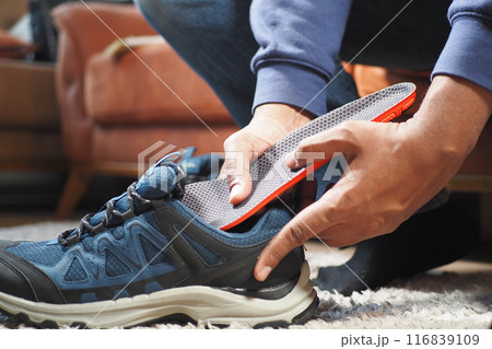 men hand putting Orthopedic insoles in shoes men hand putting Orthopedic insoles in shoes 116839109