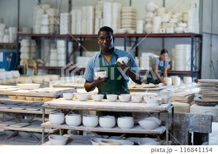 Man potter with new crafted ceramic bowls Man potter with new crafted ceramic bowls 116841154