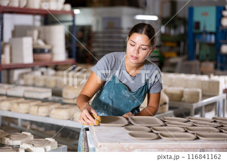 Ceramist polishing new clay plates Ceramist polishing new clay plates 116841162
