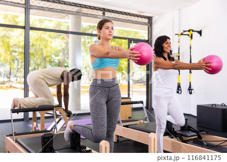 Man and woman exercising with ball at pilates lesson 116841175