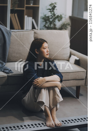 A woman with a cold with pills is treated at home chooses which drugs to take and self-medicates, checks the expiration date while sitting on the couch at home A woman with a cold with pills is treated at home chooses which drugs to take and self-medicates, checks the expiration date while sitting on the couch at home 116841274
