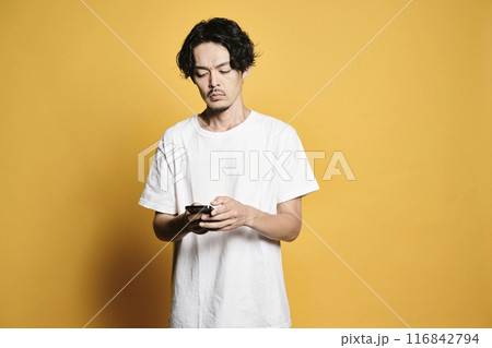 カラーバックでスマホを触る男性 カラーバックでスマホを触る男性 116842794