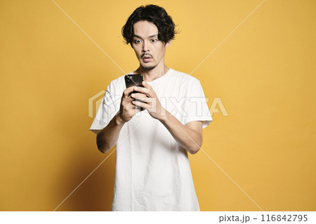 カラーバックでスマホを触る男性 116842795