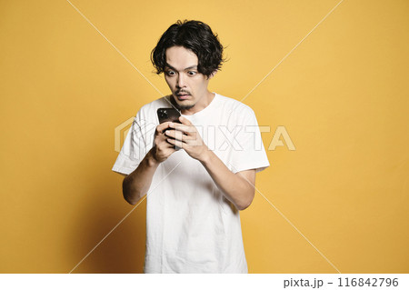 カラーバックでスマホを触る男性 116842796