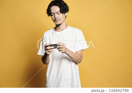 カラーバックでスマホを触る男性 116842799