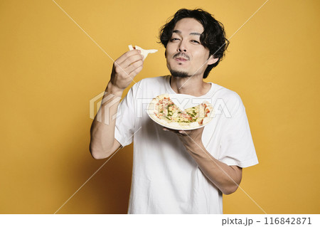 カラーバックでピザを食べる男性 116842871