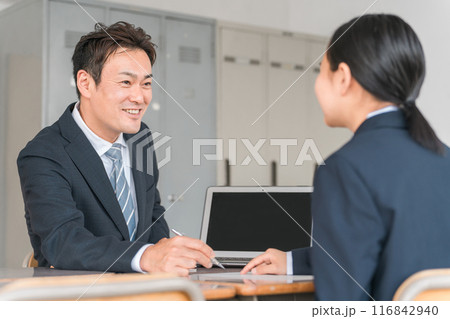 面談・進路相談・二者面談をする男性教師とブレザー姿の女子中学生 面談・進路相談・二者面談をする男性教師とブレザー姿の女子中学生 116842940