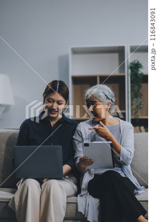 Asian elderly women and friend using social media and living room. Video streaming, happiness and conversation at a house with old people together Asian elderly women and friend using social media and living room. Video streaming, happiness and conversation at a house with old people together 116843091