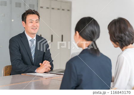 笑顔で三者面談を受ける親子と先生（中学生・高校生） 116843170