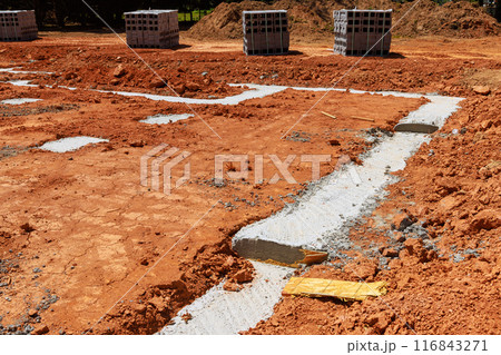 Delivery of concrete blocks to construction site with foundation for installation of cement block wall 116843271