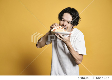 カラーバックでピザを食べる男性 116843287