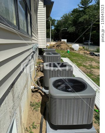 Construction new house has resulted in installation an air conditioners outside to serve needs of residents. 116843323