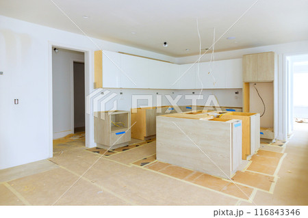 Installing new custom kitchen cabinet during construction of home improvement project 116843346