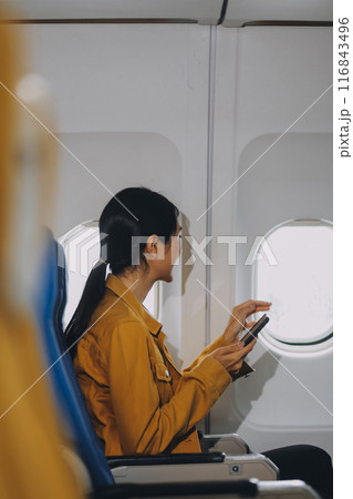 Texting on mobile chat app, Thoughtful asian people female person onboard, airplane window, perfectly capture the anticipation and excitement of holiday travel. chinese, japanese people. Texting on mobile chat app, Thoughtful asian people female person onboard, airplane window, perfectly capture the anticipation and excitement of holiday travel. chinese, japanese people. 116843496