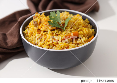 Pilaf in bowl and towel on white background, close up 116843660