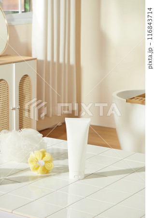 Bathroom concept photo for advertise product of cosmetic or beauty care, a blank label tube placed on the white table top, next to two bath sponges. Empty space for designing and advertising Bathroom concept photo for advertise product of cosmetic or beauty care, a blank label tube placed on the white table top, next to two bath sponges. Empty space for designing and advertising 116843714