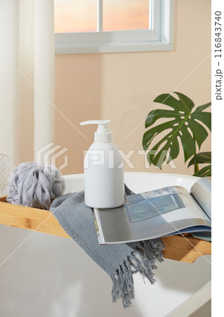 The cosmetic advertising template photo in green color tone bathroom, from front view. Above of white cabinet contains a sink with a green towel covered, a brush and tree pot, blank space in center 116843740