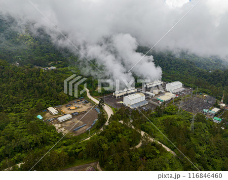 Geothermal station with steam and pipes. Renewable energy production at a power station. Mindanao, Philippines. Top view survey. 116846460