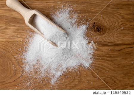salt in wooden skoop isolated on wooden background 116846626