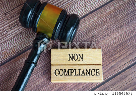 Top view of Non Compliance text engraved on wooden blocks with lawyer gavel background. Law and comliance concept. Top view of Non Compliance text engraved on wooden blocks with lawyer gavel background. Law and comliance concept. 116846673