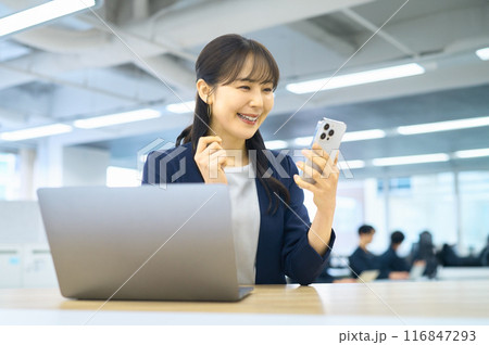 オフィスでスマホを操作する若い女性 116847293