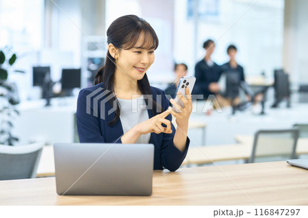 オフィスでスマホを操作する若い女性 オフィスでスマホを操作する若い女性 116847297