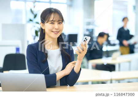 オフィスでスマホを操作する若い女性 116847300