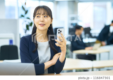 オフィスでスマホを操作する若い女性 116847301