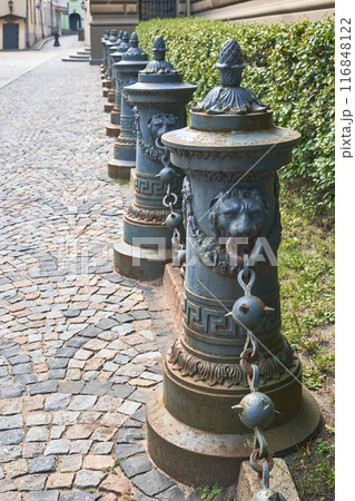 Fence made of beautiful decorative pillars, decorative columns on sidewalk. The poles are on a on footpath in old town of Riga, Latvia. 116848122