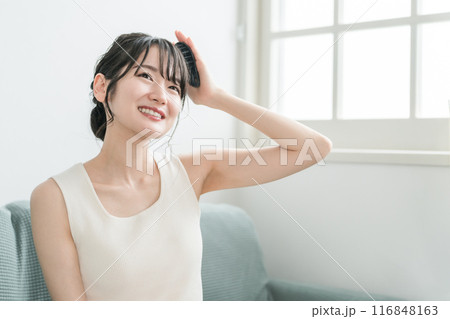 部屋で頭皮ブラッシング・ シャンプーブラシ・ヘッドブラシでヘッドマッサージ・スカルプケアをする女性 部屋で頭皮ブラッシング・ シャンプーブラシ・ヘッドブラシでヘッドマッサージ・スカルプケアをする女性 116848163