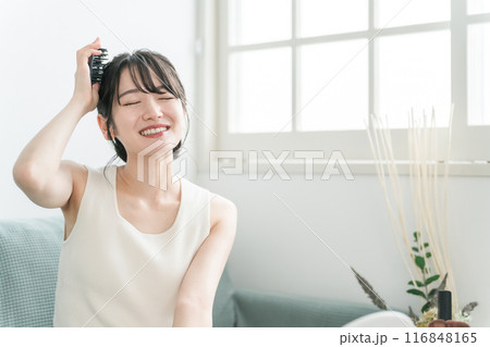 部屋で頭皮ブラッシング・ シャンプーブラシ・ヘッドブラシでヘッドマッサージ・スカルプケアをする女性 116848165