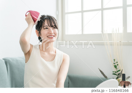 部屋で頭皮ブラッシング・ シャンプーブラシ・ヘッドブラシでヘッドマッサージ・スカルプケアをする女性 116848166