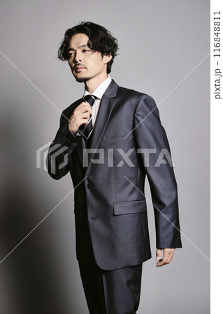 グレーバックで立つスーツを着た男性 グレーバックで立つスーツを着た男性 116848811