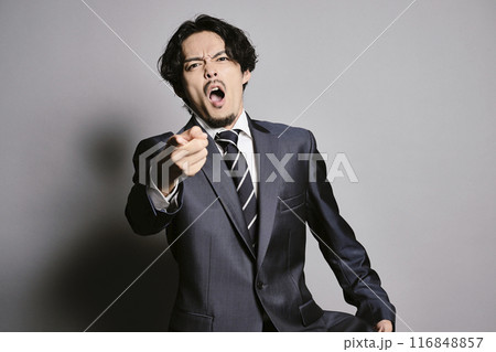 グレーバックで立つスーツを着た男性 116848857