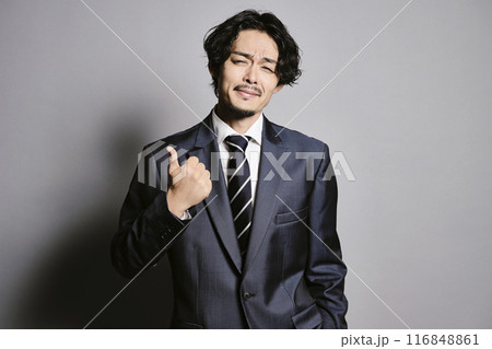 グレーバックで立つスーツを着た男性 116848861