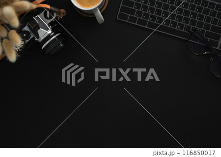 A vintage camera, keyboard and a cup of coffee on black background. Flat lay, Top view with copy space 116850017