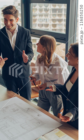 Group of professional team design engineers working with project documents in modern office 116850250