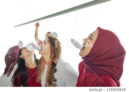 A group of women are eating crackers contest while wearing red clothing 116850826