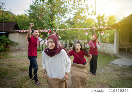 A group of people are playing a game of tag in a backyard 116850842