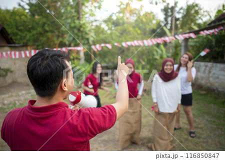 A man in a red shirt is holding a megaphone 116850847