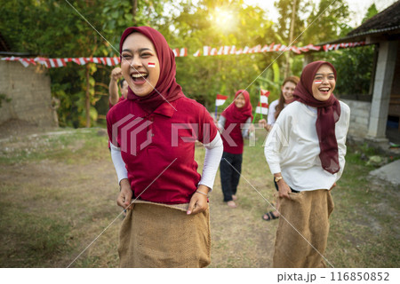 A group of women are laughing and playing a game in a field A group of women are laughing and playing a game in a field 116850852