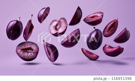 Captivating image featuring plum halves suspended in air against a soothing purple backdrop 116851398