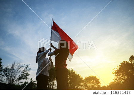 Portrait of two Indonesian women holding an Indonesian flag together Portrait of two Indonesian women holding an Indonesian flag together 116851418