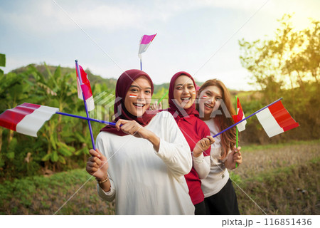 Portrait group of Indonesian women with excited expressions holding small Indonesian flag 116851436