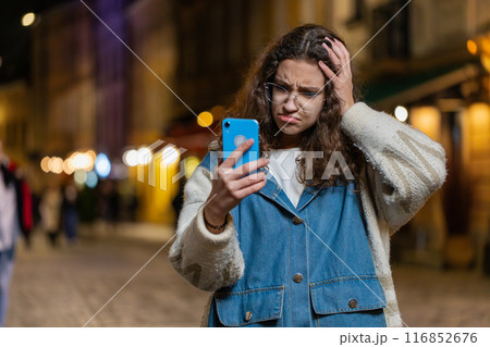 Girl using smartphone typing browsing loses becoming surprised sudden lottery results bad news 116852676